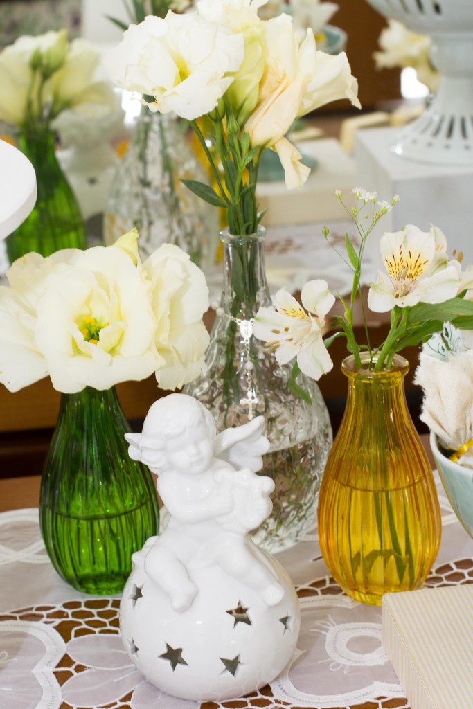 Imagens de vidros coloridos, arranjos florais e anjos pontuam a decoração.