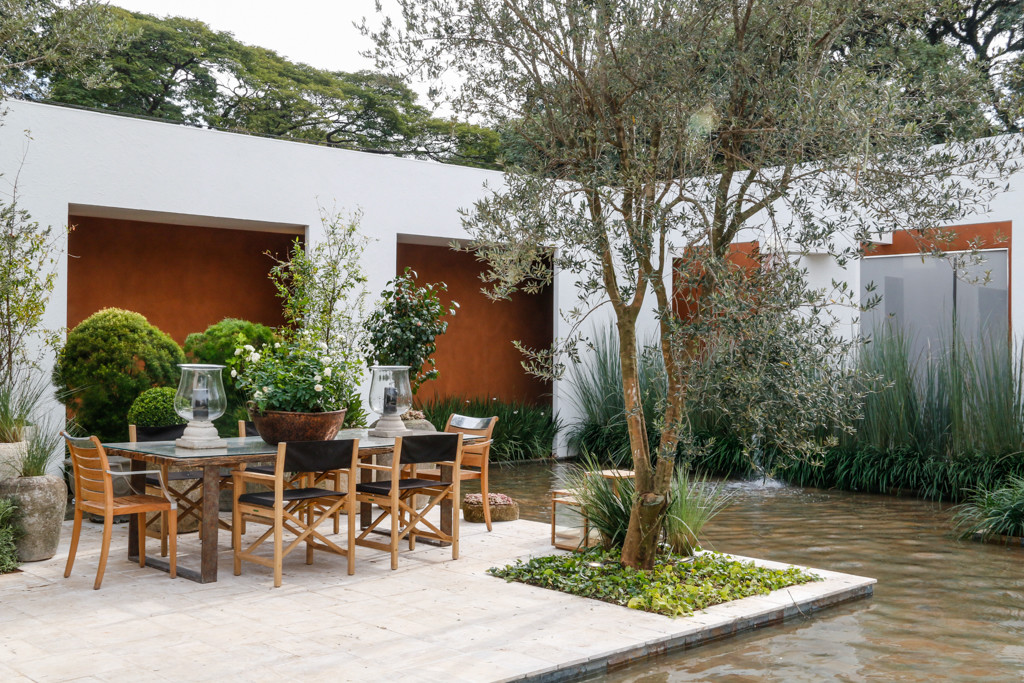 Imagem de Enquanto os cavalos podem se exercitar na área externa em meio à vegetação e ao espelho d'água, proprietários e amigos relaxam ao sabor do clima campestre